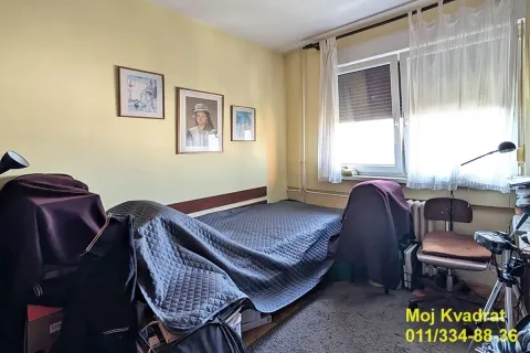 Manja spavaća soba sa krevetom, prozorom i slikama na zidu. - image 10