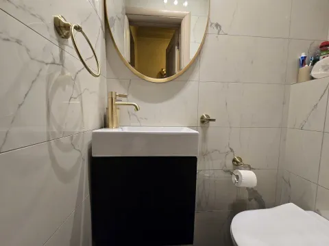 Moderne kupatilo sa umivaonikom, zlatnim slavinama i ogledalom. - image 15