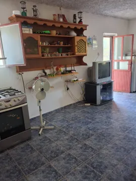 Small kitchen with wooden cabinetry, stove, and blue floor tiles. - image 4