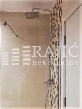 View of the shower cabin with modern fixtures and tiles in the bathroom. - image 13