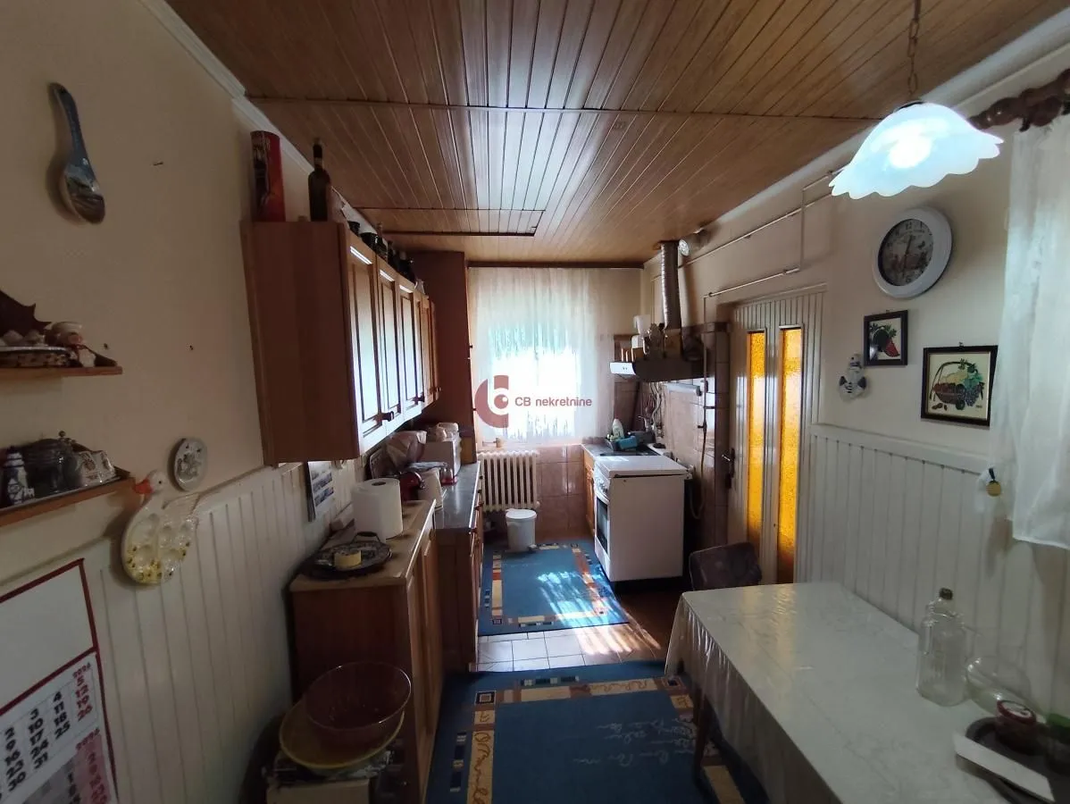 Smaller kitchen with a dining table and wood paneling on the ceiling.