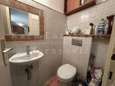 Manje kupatilo obloženo keramičkim pločicama sa umivaonikom, ogledalom i toaletom. - image 10
