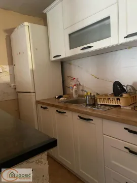 Smaller kitchen with white cabinets, a sink, and a refrigerator. - image 15