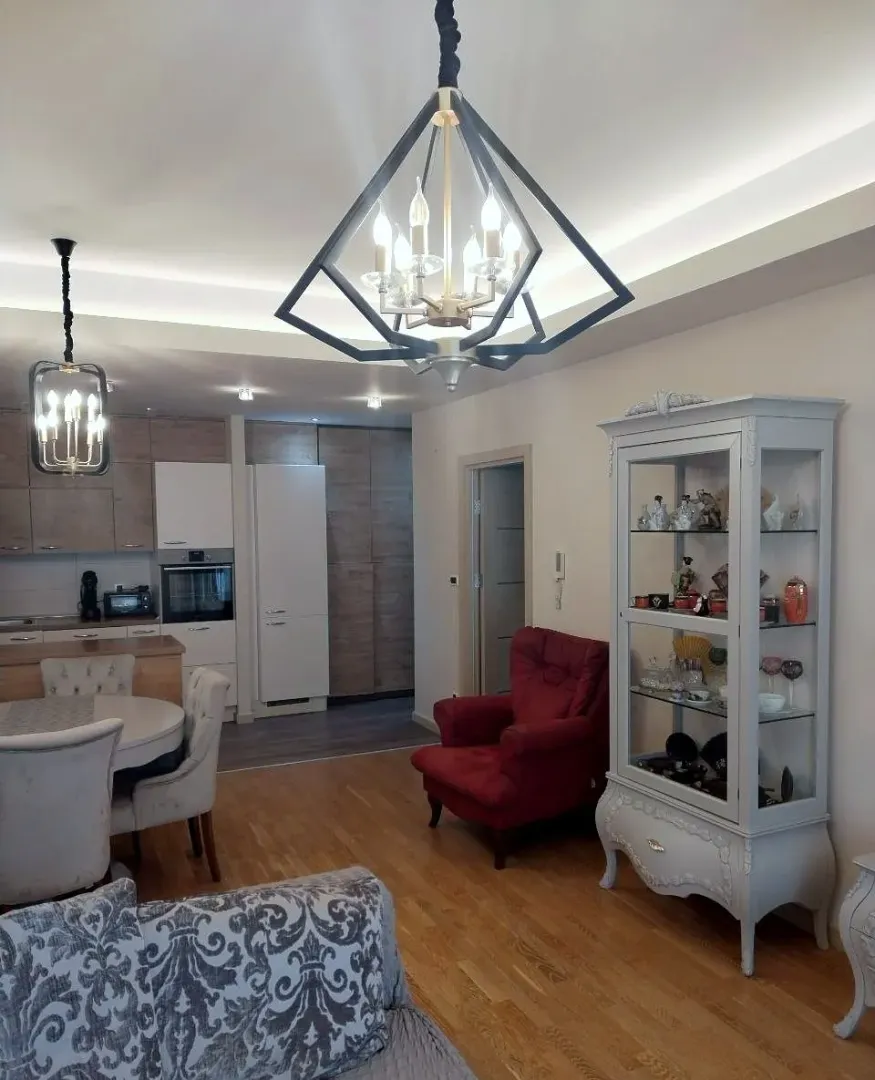 Living room with dining area and kitchen in the background.
