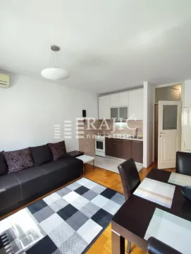 Living room with a sofa and dining area in an open-plan layout with the kitchen. - image 2