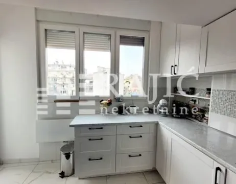 Modern white kitchen with a window and city view. - image 5