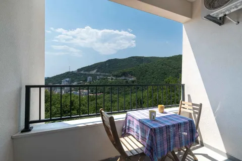 Furnished balcony with a table, chairs, and a view of the hills. - image 7
