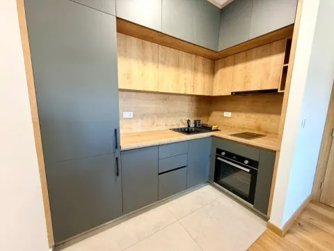 Modern kitchen with dark green cabinets and wooden details. - image 8