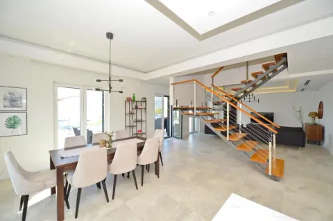 Spacious bright living room with dining area and staircase. - image 2