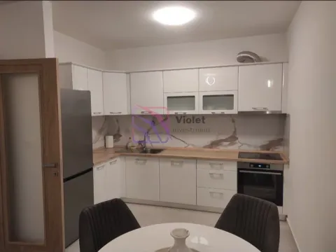 Modern white kitchen with built-in appliances and a dining table. - image 8