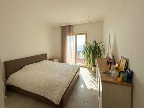 Spavaća soba sa bračnim krevetom, komodom i izlazom na balkon sa pogledom na more. - image 4