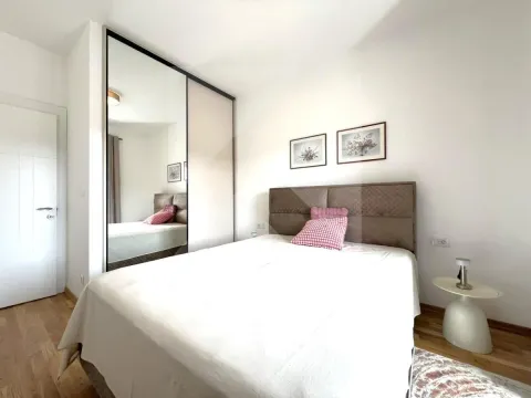 Bedroom with a double bed, large mirrored wardrobe, and hardwood flooring. - image 6