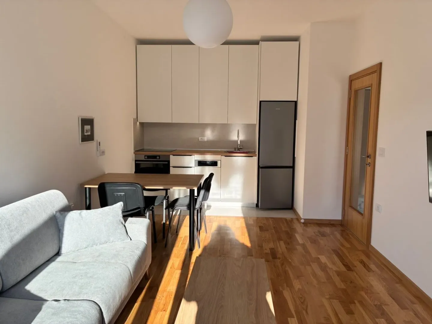 Living room with kitchen and dining area in a modern apartment.