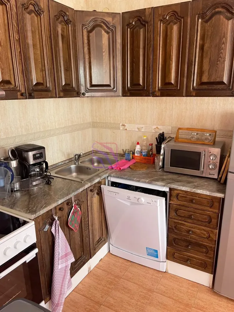 Kitchen with wooden cabinets, a sink, and built-in home appliances.