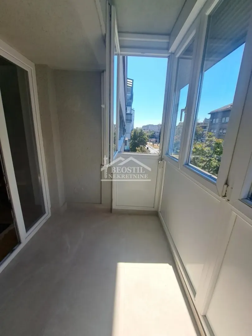 Zastakljeni balkon sa pogledom na ulicu.