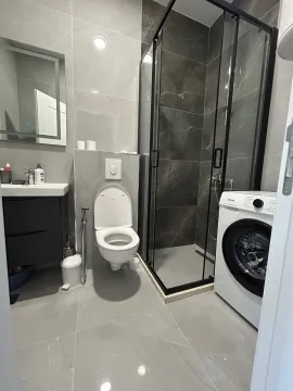 Moderne kupatilo sa tuš kabinom, umivaonikom, WC šoljom i veš mašinom. - image 9