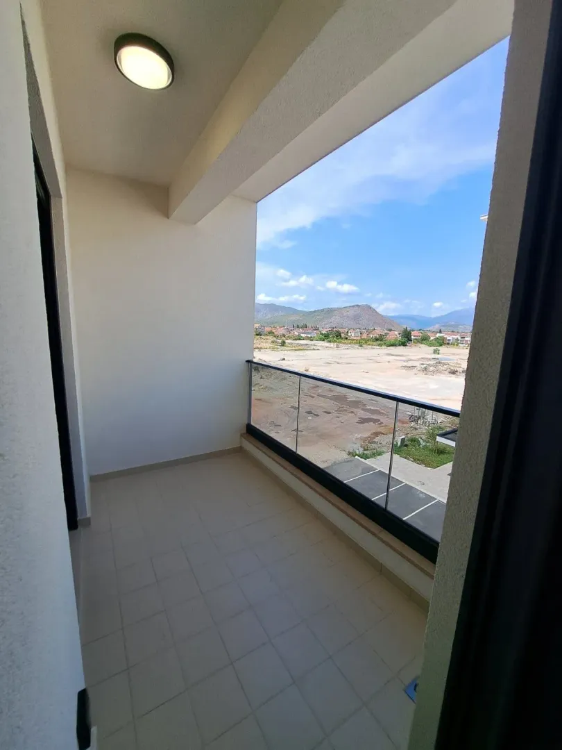 Unfurnished balcony with a glass railing and a view of the surroundings.