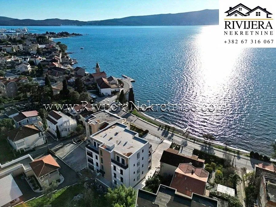 Pogled iz vazduha na stambenu zgradu i obalu mora sa naseljem.