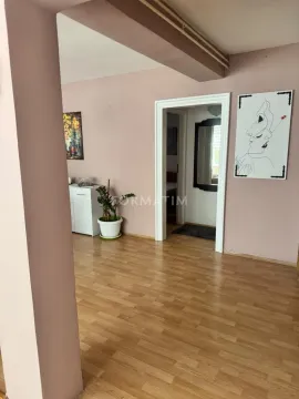 Pogled na deo dnevne sobe sa laminatom i slikama na zidu. - image 12