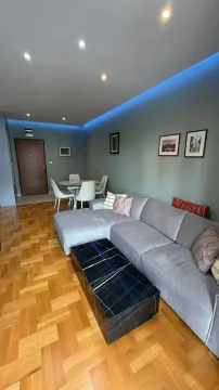 Living room with a sectional sofa, coffee table, and dining table in the background. - image 16