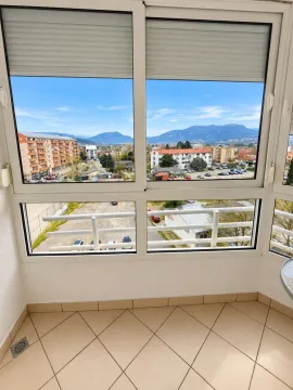 Zastakljeni balkon sa pogledom na grad i okolne planine. - image 8