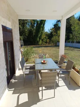 Covered terrace with a table and chairs and a view of the yard. - image 10
