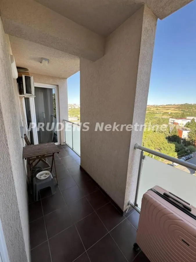 Covered balcony space with a small table and a view of the surroundings.