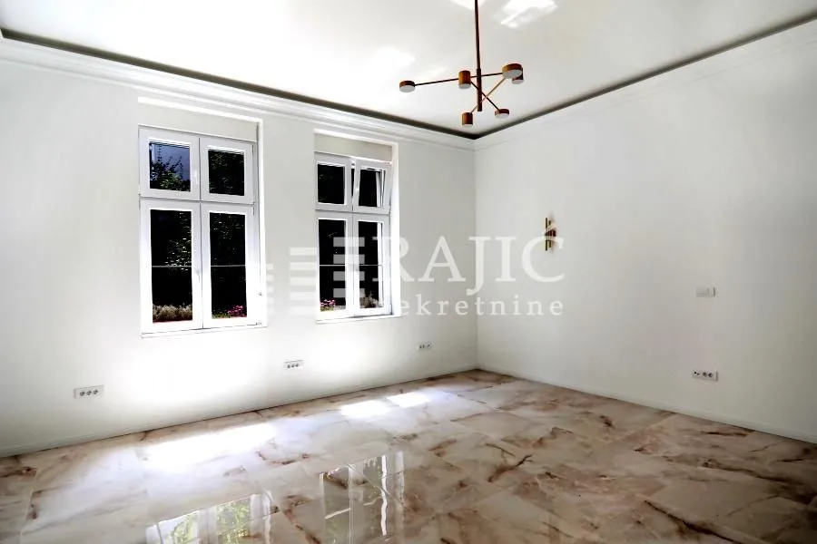 Empty room with bright marble floor and two windows.