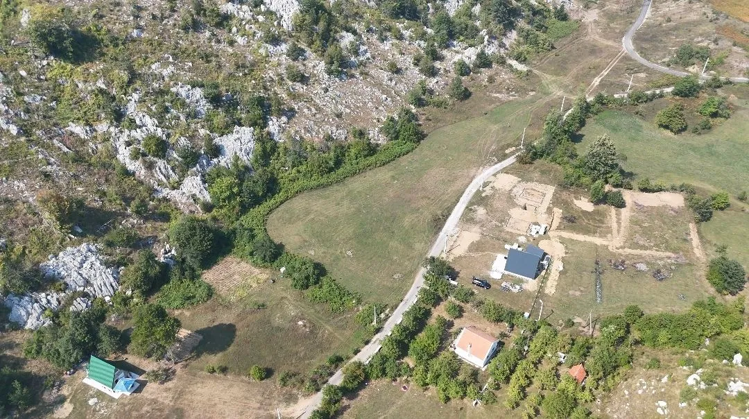 Pogled iz vazduha na seosko imanje sa kućama i okolnim zelenilom.