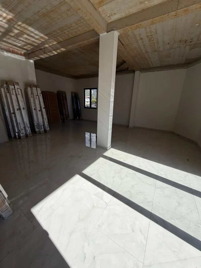 Interior of an empty room under construction with ceramic tile flooring.