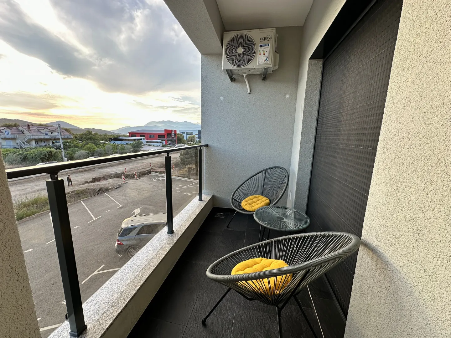 Manji natkriveni balkon sa garniturom za sjedenje i pogledom na okolinu.