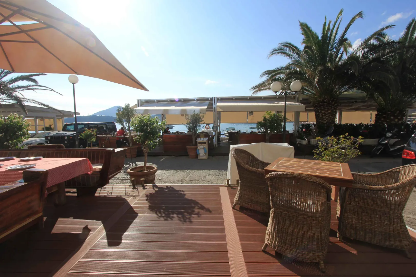 Restaurant terrace with seating furniture and a sea view.
