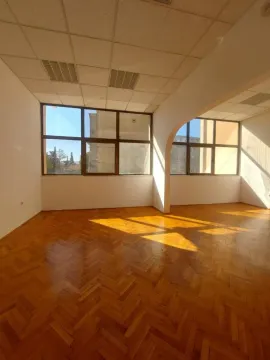 Empty room with parquet flooring and large windows letting in sunlight. - image 6