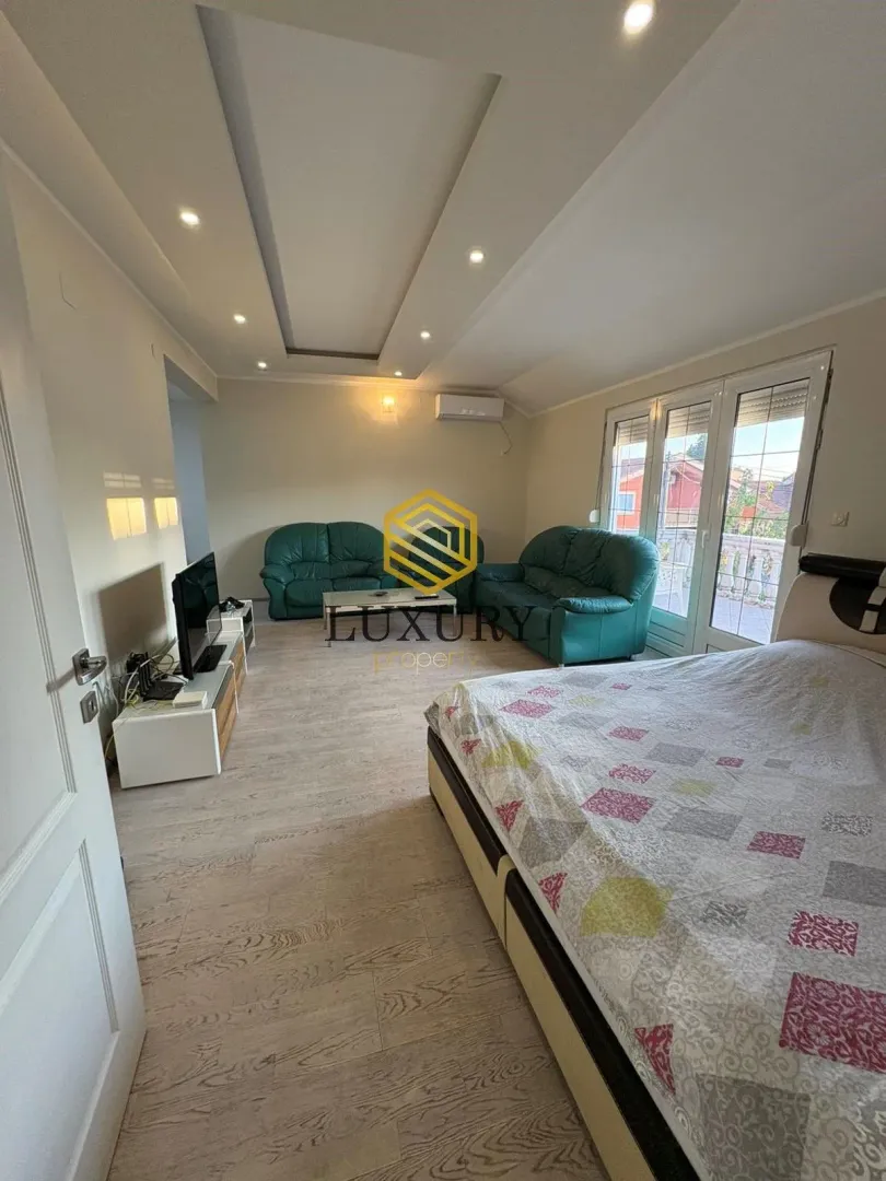 Spacious bedroom with a double bed and a seating set.