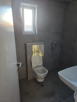 Manje kupatilo sa tamnim pločicama, wc šoljom i umivaonikom. - image 8