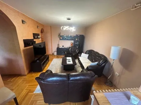 Dnevna soba sa garniturom za sedenje, TV-om i parketom na podu. - image 3
