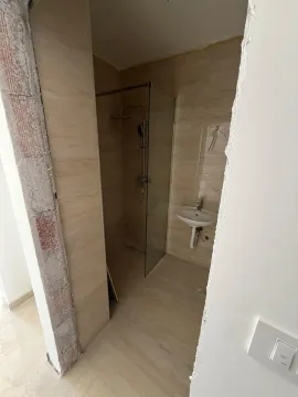 Pogled na kupatilo sa tuš kabinom i umivaonikom u toku završnih radova. - image 12