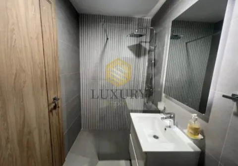 Modern bathroom with a walk-in shower, washbasin, and mirror. - image 6