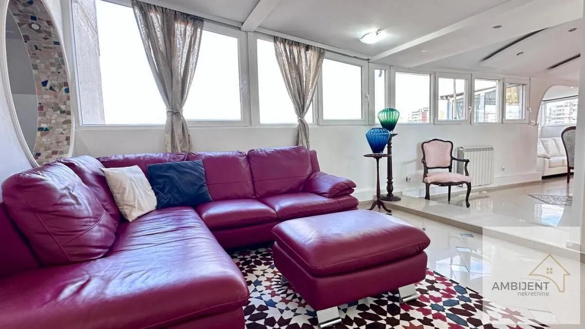 Spacious living room with a large sofa and large windows.