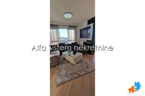 Dnevna soba sa garniturom, stočićem i televizorom na zidu. - image 14