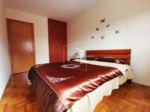 Bedroom with a double bed, wooden wardrobe, and laminate flooring. - image 7