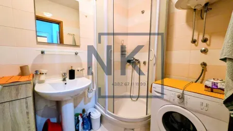 Bathroom with a shower cabin, washbasin, and washing machine. - image 11