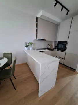 Modern kitchen with a breakfast bar and dining table. - image 6