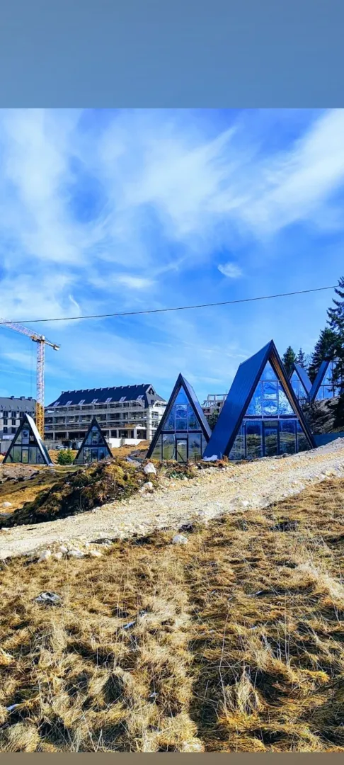 Pogled na spoljašnjost modernih A-frame kuća u izgradnji.