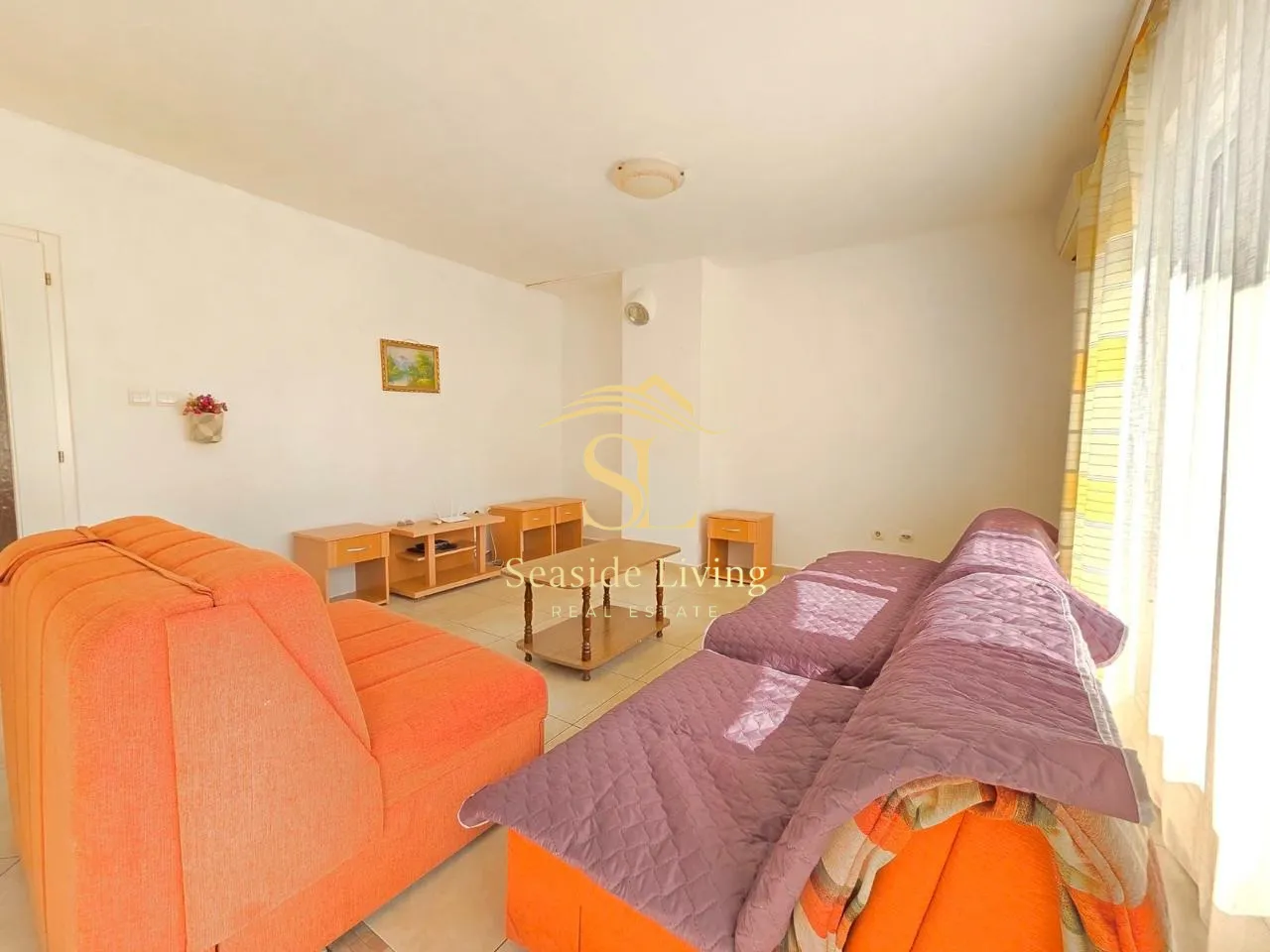 Living room with a sofa set and wooden furniture pieces.