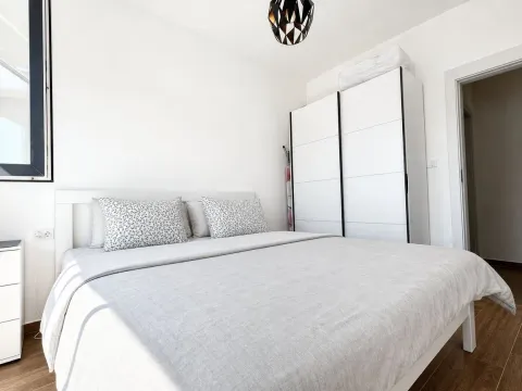 Svjetla spavaća soba sa bračnim krevetom i bijelim garderoberom. - image 7