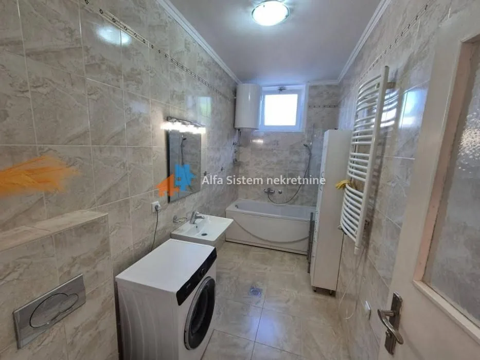Bathroom equipped with a bathtub, washbasin, and washing machine.