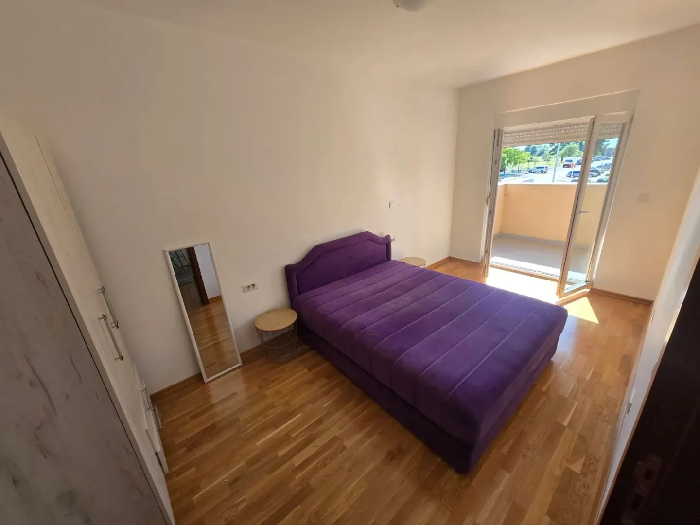 Svjetla spavaća soba sa bračnim krevetom i izlazom na terasu.
