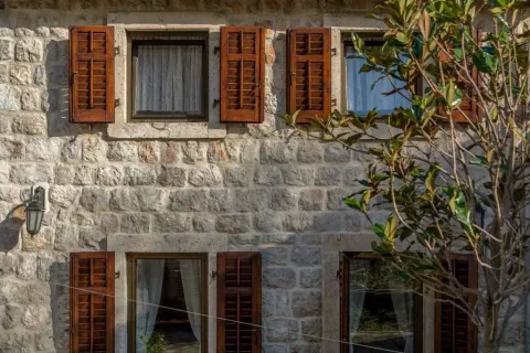 Kamena fasada tradicionalne kuće sa drvenim škurama. - image 12