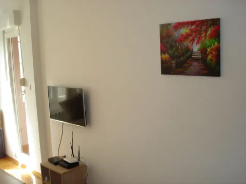 White wall with a television and an art painting. - image 4